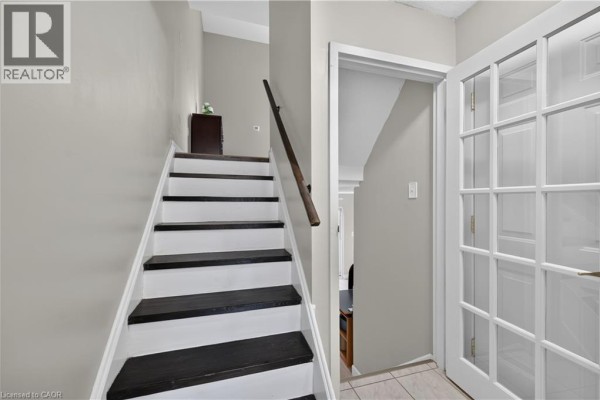 Living room view showing staircase and decorative elements, natural light - 23 Rosedale Court, Hamilton