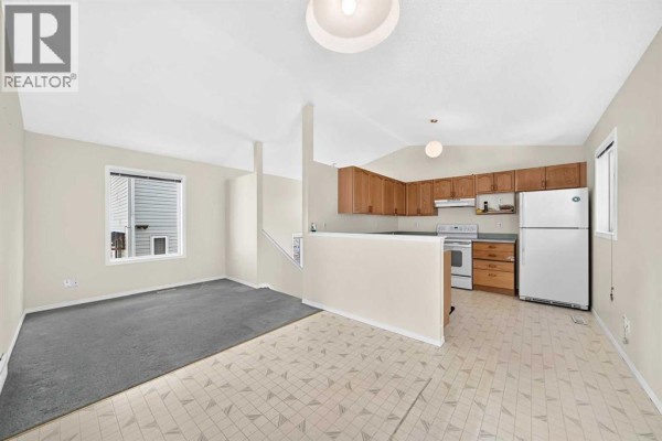 Kitchen and dining area with sliding glass doors leading to a deck. - 23 San Diego Manor Ne, Calgary