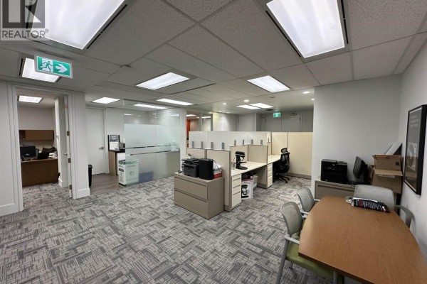 Another angle of the office space showing cubicles, desks, computers, and doorways to adjacent rooms. - 230 171 W 171 West Esplanade Avenue, North Vancouver