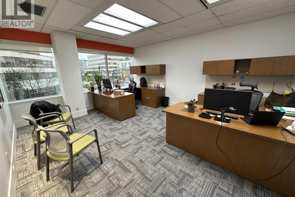 Office area with executive desks, chairs, filing cabinets, and large windows overlooking a cityscape. - 230 171 W 171 West Esplanade Avenue, North Vancouver