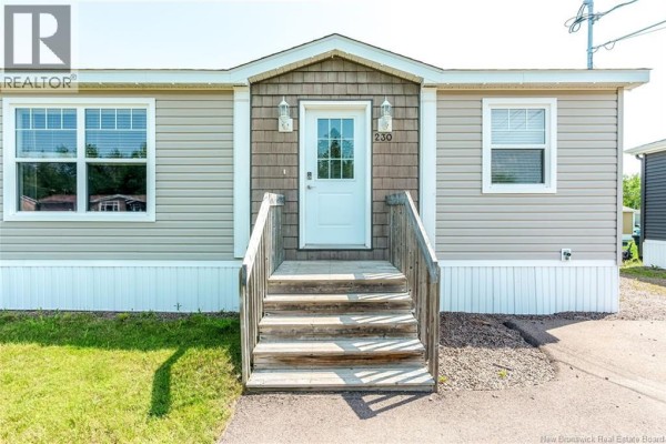 Spacious kitchen with dark brown cabinets, stainless steel appliances, and a central island. - 230 Bonaventure Street, Shediac
