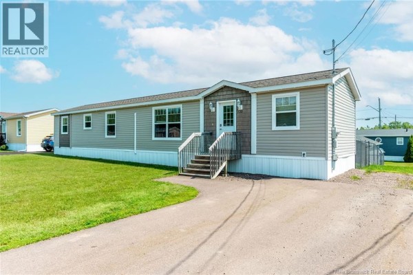 Kitchen area with dark brown cabinets, stainless steel refrigerator, and a round dining table. - 230 Bonaventure Street, Shediac