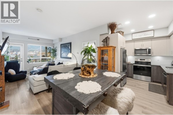 Kitchen with light wood cabinets, grey countertop, stainless steel sink and dishwasher. - 2301 Carrington Road Unit# 419, West Kelowna