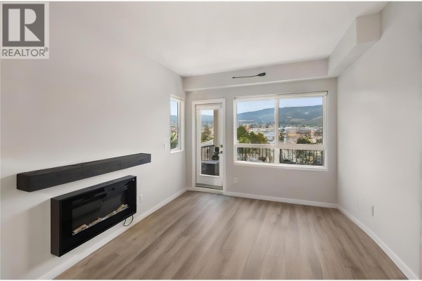 Bedroom with beige carpet, neutral walls, and white overhead cabinets. - 2301 Carrington Road Unit# 419, West Kelowna