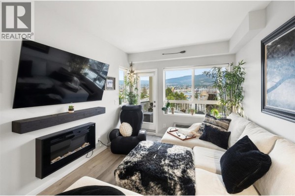 Open concept living space with wood floors and a wooden bar area. - 2301 Carrington Road Unit# 419, West Kelowna