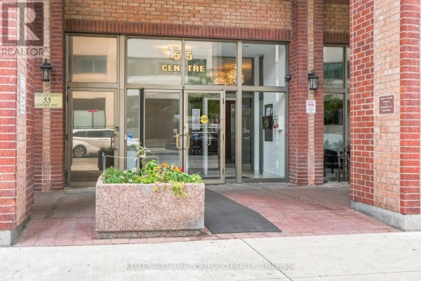 Entrance to 55 Centre Avenue apartment building with glass doors and planters. - 2304 - 55 Centre Avenue, Toronto