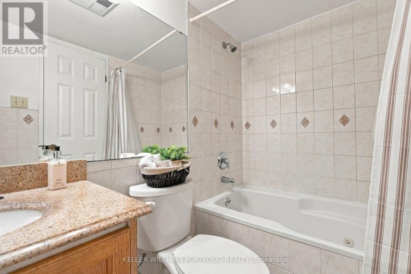 Bathroom with bathtub, toilet, vanity, and tiled walls. - 2304 - 55 Centre Avenue, Toronto