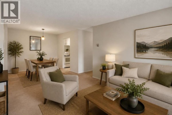 Living and dining area of an apartment with beige furniture, fireplace, and a view of the kitchen. - 2306, 315 Southampton Drive Sw, Calgary