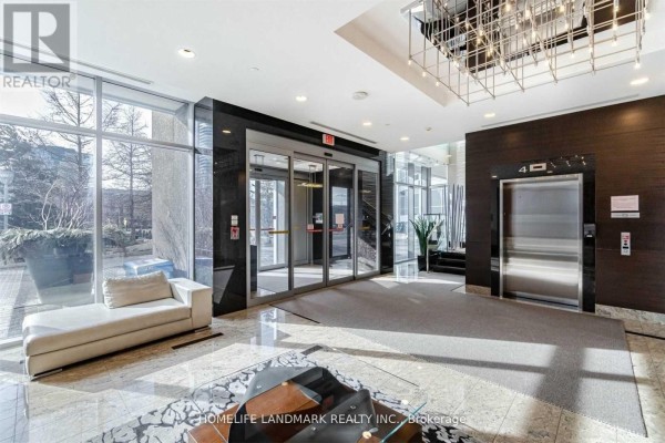 Building lobby with elevator, seating area, marble floors, and glass entrance. - 2306 - 151 Village Green Square, Toronto