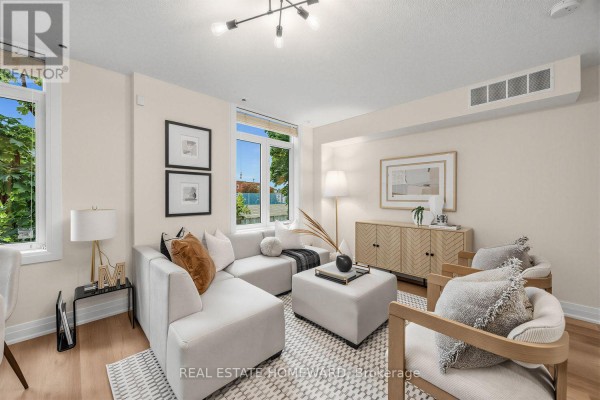 Living room with a sectional sofa, two accent chairs, and a credenza against a cream wall. - 2306 - 23 Sudbury Street, Toronto