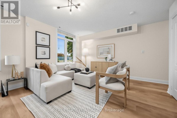 Living room featuring light wood floors, a white sectional, and two chairs. - 2306 - 23 Sudbury Street, Toronto