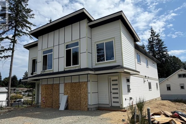 Corner exterior view of a modern duplex construction showing siding and windows. - 2306 Sparrow Lane, Nanaimo