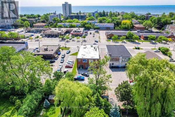 Aerial perspective highlighting the commercial property with nearby parking and residential areas. - 2307 - 2309 Lakeshore Road W, Oakville