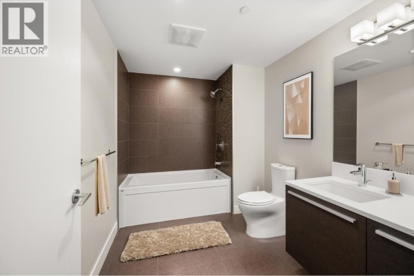 Bathroom with a bathtub, shower, dual sinks, and dark tile accents. - 2308 2008 Rosser Avenue, Burnaby