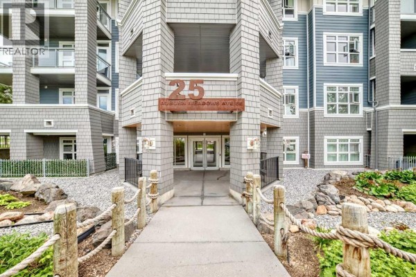 Close-up of the building entrance at 25 Auburn Meadows Avenue SE, with a stone walkway and rope railings. - 231, 25 Auburn Meadows Avenue Se, Calgary