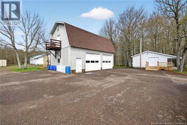 Large room with white walls, speckled flooring, multiple tables, chairs, mirrors, and a television mounted on the wall. - 231 Rue Delagarde, Saint Isidore