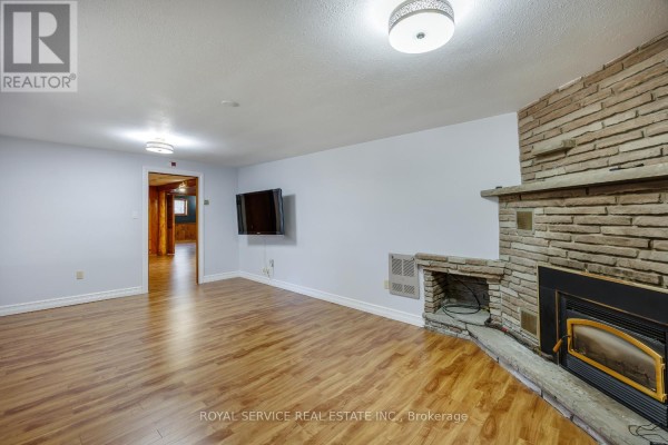 Living room with stone fireplace and wall-mounted TV - 2311 Division Street N Hamilton Township