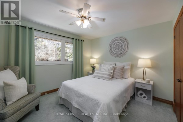 Bedroom with white bed, armchair, and light green walls - 2311 Division Street N Hamilton Township