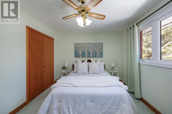 Bedroom with white bed, wood closet, wall art, and window - 2311 Division Street N Hamilton Township