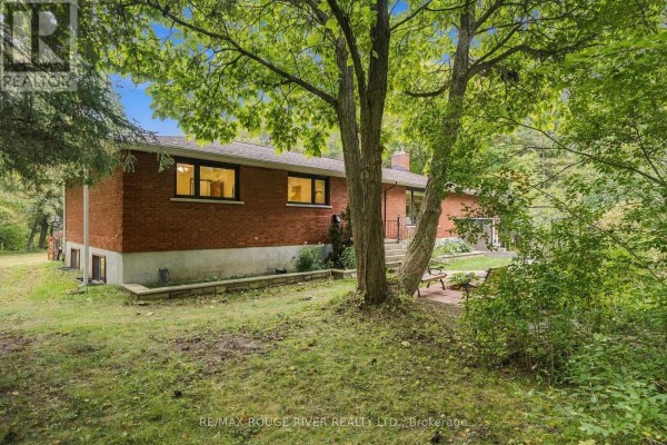A compact kitchen with white cabinets, white appliances, and wood-paneled walls. - 2311 Division Street N, Hamilton Township