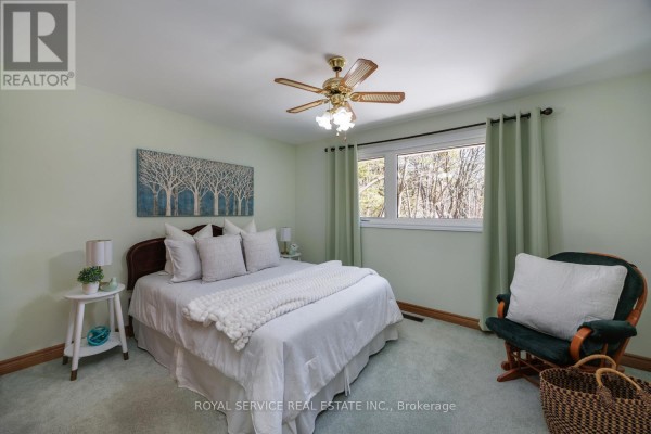 Bedroom with bed, glider chair, and artwork - 2311 Division Street N Hamilton Township
