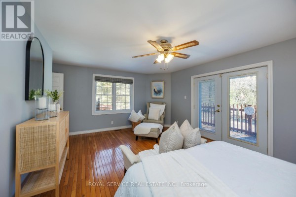 Bedroom with hardwood floors, ceiling fan, double doors, and wicker dresser - 2311 Division Street N Hamilton Township