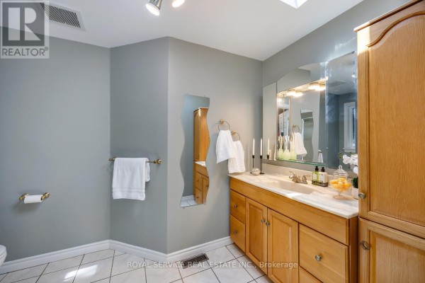 Bathroom with double vanity, wooden cabinets, and large mirror - 2311 Division Street N Hamilton Township