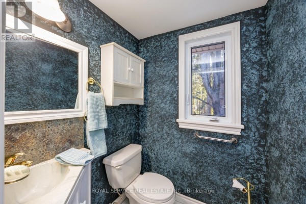 Bathroom with blue patterned wallpaper, sink, toilet, and mirror - 2311 Division Street N Hamilton Township