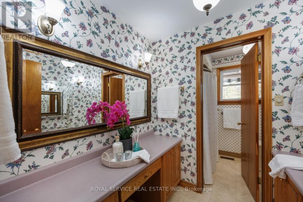Bathroom with floral wallpaper, vanity, and mirror - 2311 Division Street N Hamilton Township