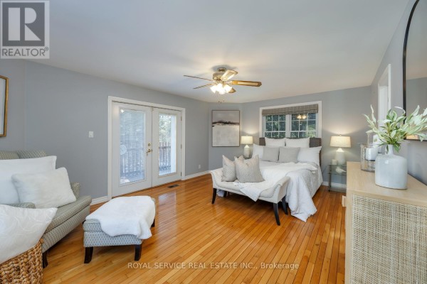 Bedroom with king bed, hardwood floors, double doors, and bench - 2311 Division Street N Hamilton Township