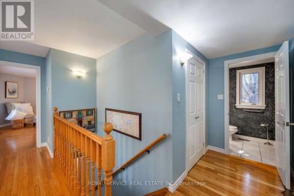 Hallway with hardwood floors, banister, and bathroom entrance - 2311 Division Street N Hamilton Township