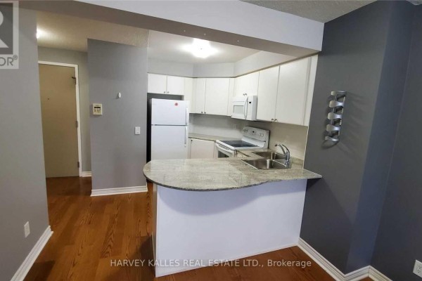 Kitchen with white cabinets, granite counters, stainless steel sink, and hardwood floors. - 2313 - 763 Bay Street, Toronto