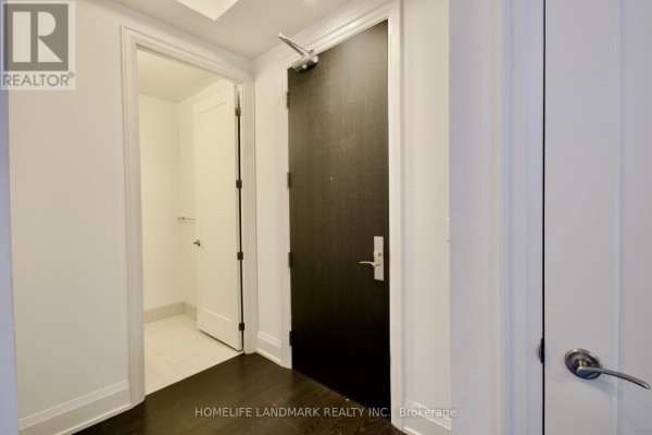 Apartment entrance hallway with dark wood floor and white walls. - 232 - 20 Fred Varley Drive, Markham
