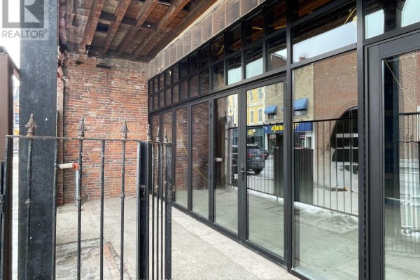 Close-up of black-framed glass doors and windows on the lower level of a brick building. - 232 Front Street, Belleville