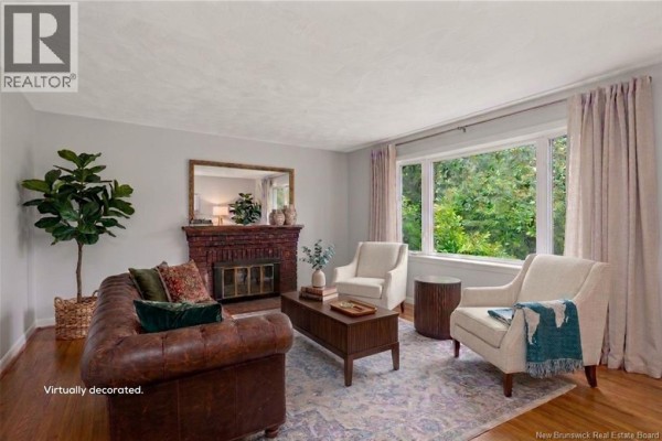 Interior view of a home's entryway with a white door, wood floors, and textured wallpaper. - 232 Leslie Street, Moncton