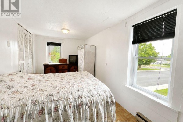 Bedroom with floral bedspread and wooden dresser - 232 Regent Street Hawkesbury