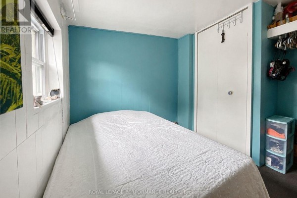 Bedroom with teal paneled walls, white paneled walls, bed, and closet - 232 Regent Street Hawkesbury