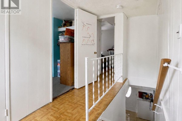Hallway with parquet floor, white railing, and open closet - 232 Regent Street Hawkesbury