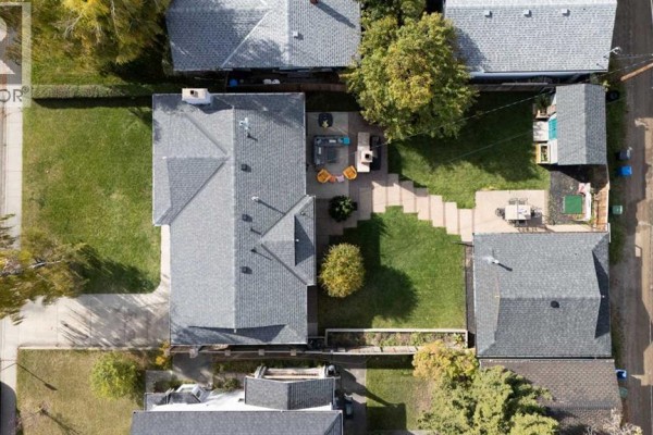 Aerial view of the backyard with a patio, grass, and outdoor dining area. - 2320 58 Avenue Sw, Calgary