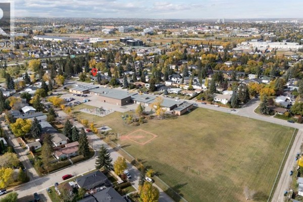 Aerial view of a school and sports field adjacent to a residential neighborhood. - 2320 58 Avenue Sw, Calgary