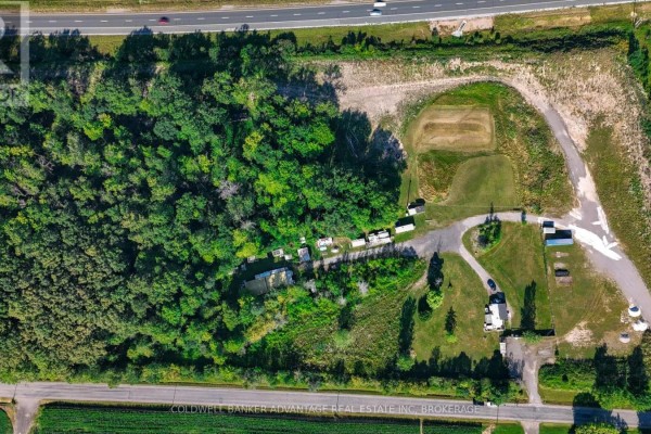 Overhead view of 2323 Kottmeier Road showing a wooded area, fields, and structures. - 2323 Kottmeier Road, Thorold