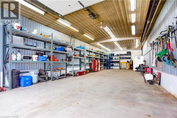 Garage with storage shelves, tools, and a red car - 23247 Beattie Drive Elgin