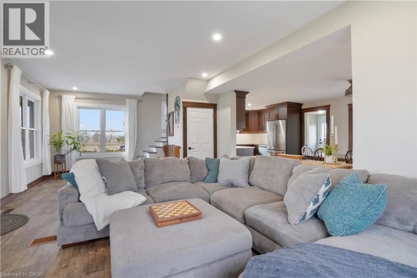 Large sectional sofa and open-concept living room leading to kitchen - 23247 Beattie Drive Elgin