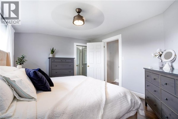 Modern bedroom with a bed, dressers, ceiling fan, and mirror - 23247 Beattie Drive Elgin