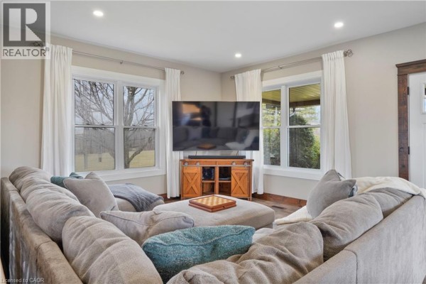 Living room with sectional sofa, TV, and large windows - 23247 Beattie Drive Elgin