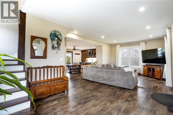 Living room with sectional sofa and wood floors, open to dining and kitchen - 23247 Beattie Drive Elgin