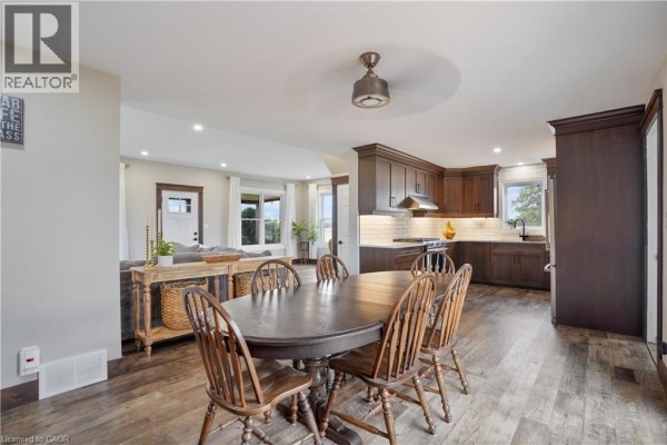 Dark wood dining table and chairs in open concept dining room connected to kitchen - 23247 Beattie Drive Elgin