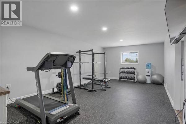 Home gym with treadmill, weight rack, and dumbbells - 23247 Beattie Drive Elgin