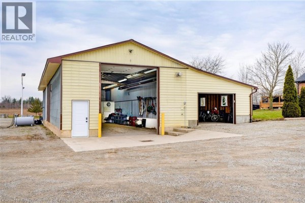 Detached garage with roll-up door, motorcycles, and fuel tank - 23247 Beattie Drive Elgin
