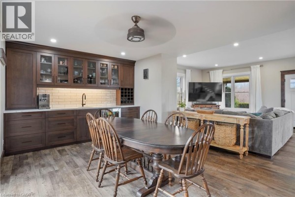 Dark wood dining set and built-in cabinetry, adjacent to living area with sofa and TV - 23247 Beattie Drive Elgin